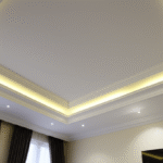 Sala de estar com iluminação indireta suave e aconchegante proporcionada por sancas de gesso.