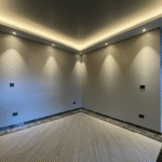 Sala de estar com paredes em gesso liso e iluminação embutida